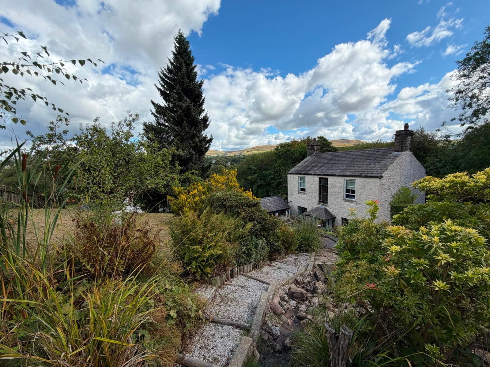 Gravel garden path leading to the cottage with the moors behind