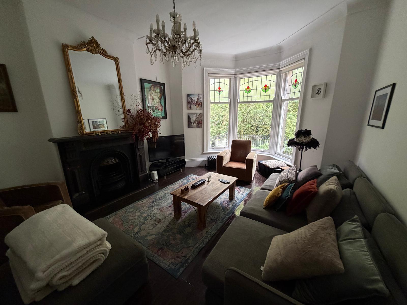 Living room with an original fireplace, chandelier and bay windows