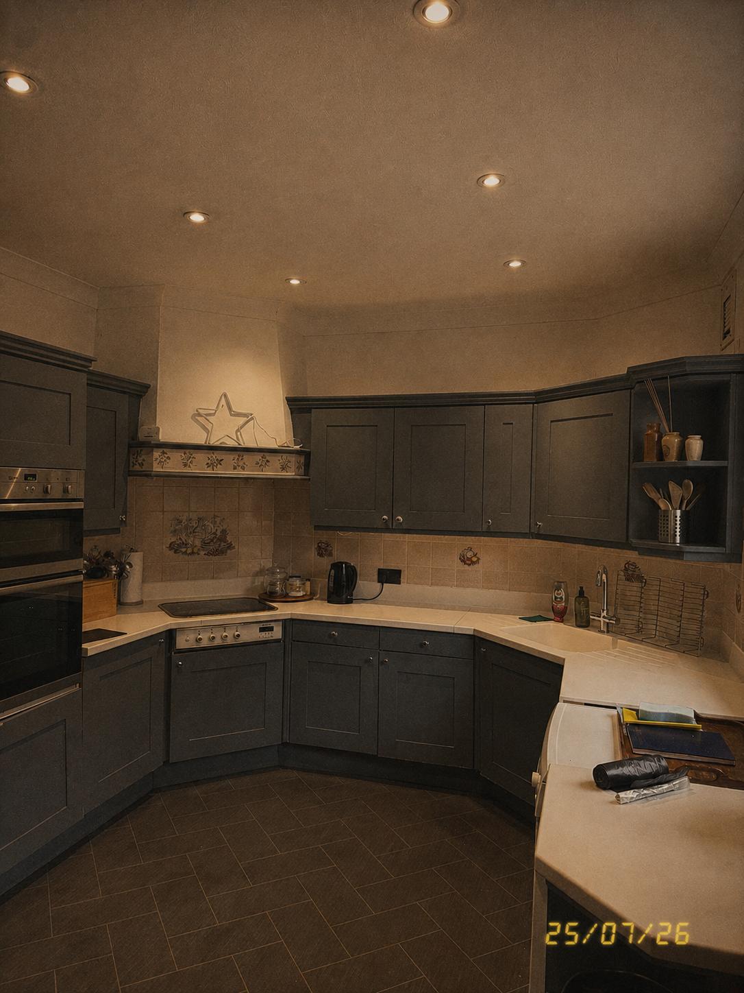 Kitchen with dark cabinets, tiled floors and a curved counter